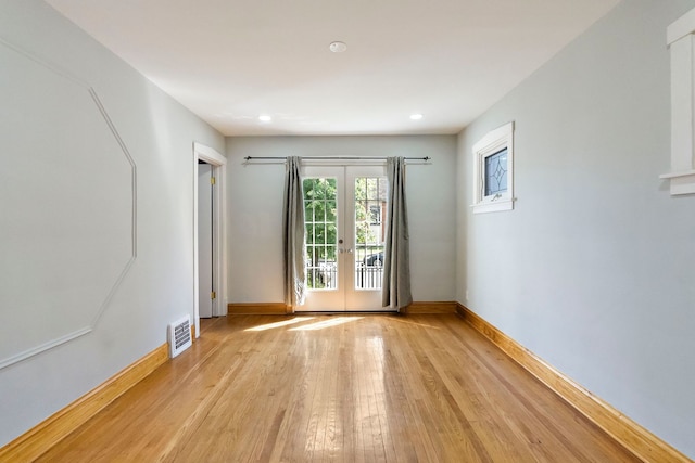 unfurnished room with light wood-type flooring and french doors