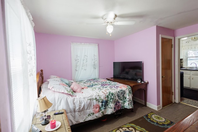 bedroom with connected bathroom, light colored carpet, ceiling fan, and sink