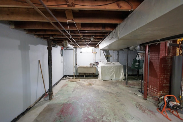 basement with washing machine and dryer, water heater, and sink