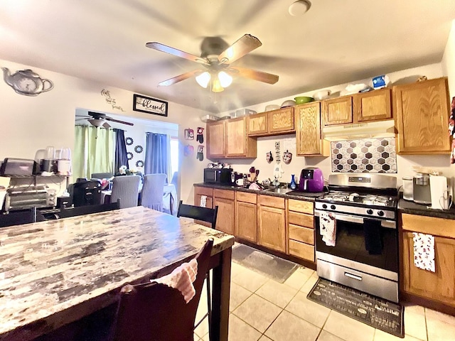 16404 Homan Ave, Markham, IL 60428 - kitchen with gas stove, black microwave, a ceiling fan, dark countertops, and under cabinet range hood