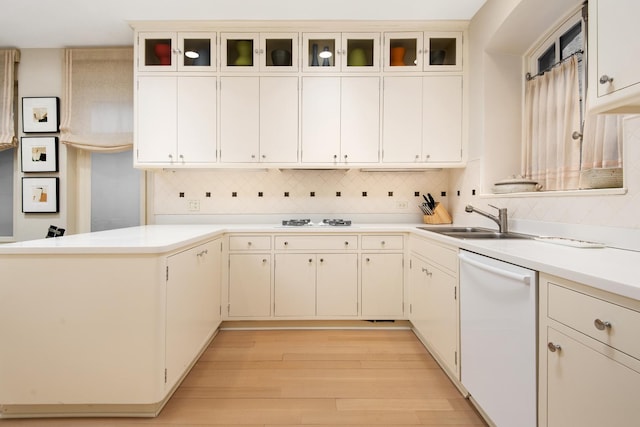 kitchen with sink, white appliances, white cabinetry, backsplash, and light wood-type flooring