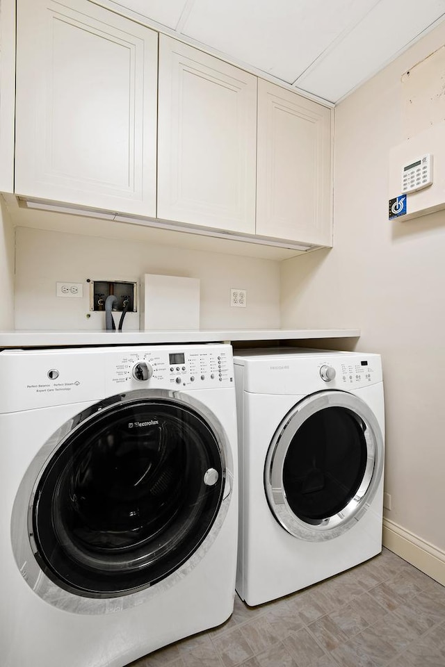 laundry area with washer and dryer and cabinets