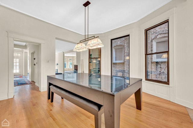 dining area featuring crown molding and light wood-type flooring