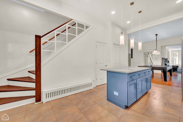 kitchen featuring light tile patterned floors, pendant lighting, blue cabinets, and a center island