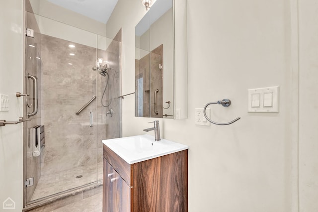 bathroom featuring a shower with shower door and vanity