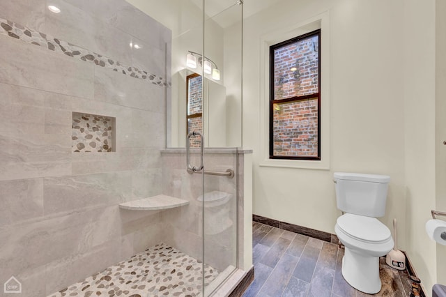 bathroom featuring walk in shower, hardwood / wood-style flooring, and toilet