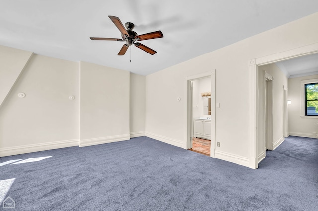 spare room featuring dark colored carpet and ceiling fan