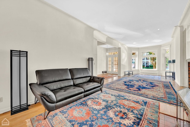 living room featuring french doors, light wood-type flooring, and ornamental molding