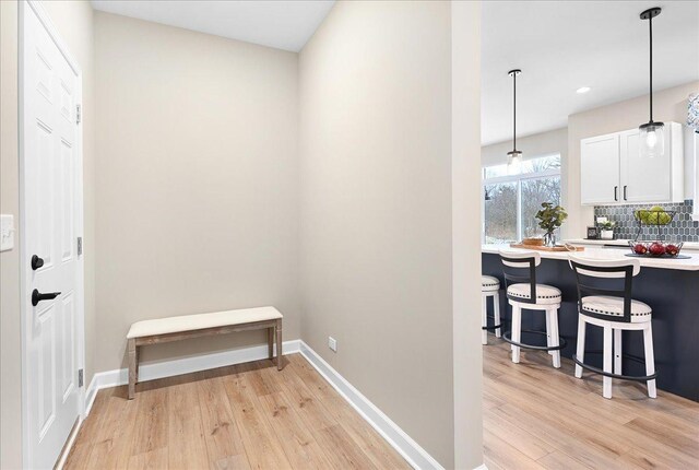 hall with light wood finished floors and baseboards