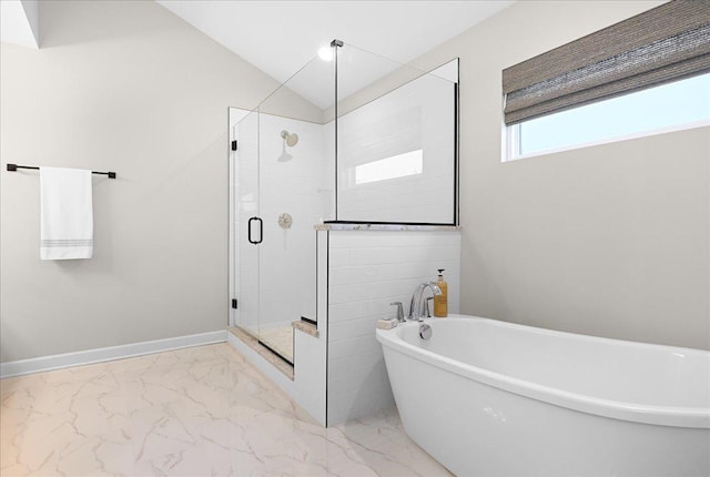 bathroom featuring baseboards, vaulted ceiling, marble finish floor, a soaking tub, and a stall shower