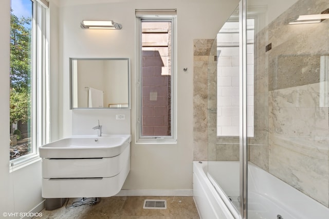 bathroom with vanity, tile patterned flooring, bath / shower combo with glass door, and a wealth of natural light