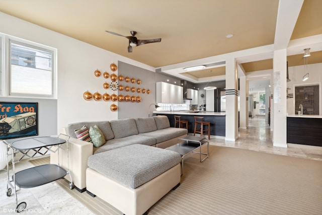 living room featuring sink, light tile patterned floors, and ceiling fan