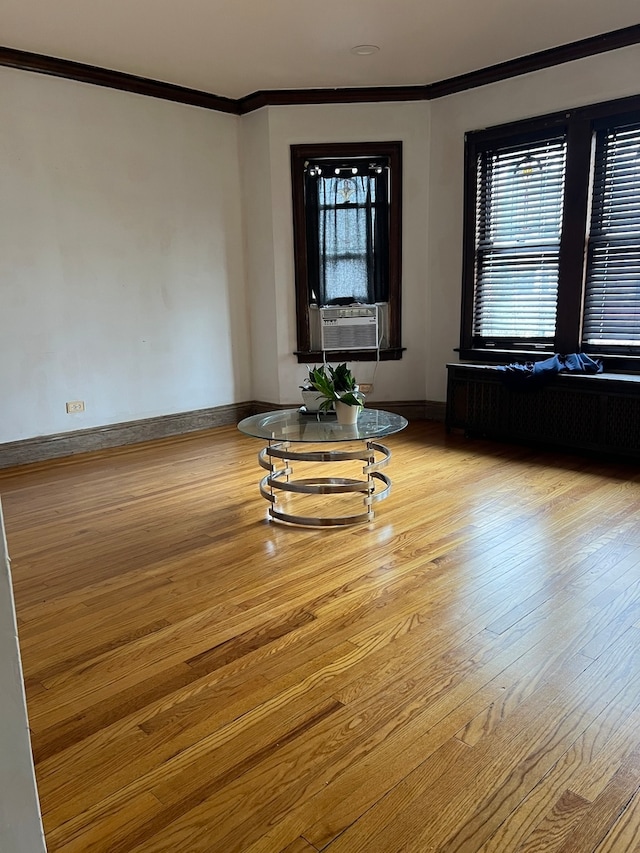 unfurnished living room featuring light hardwood / wood-style flooring, crown molding, and plenty of natural light