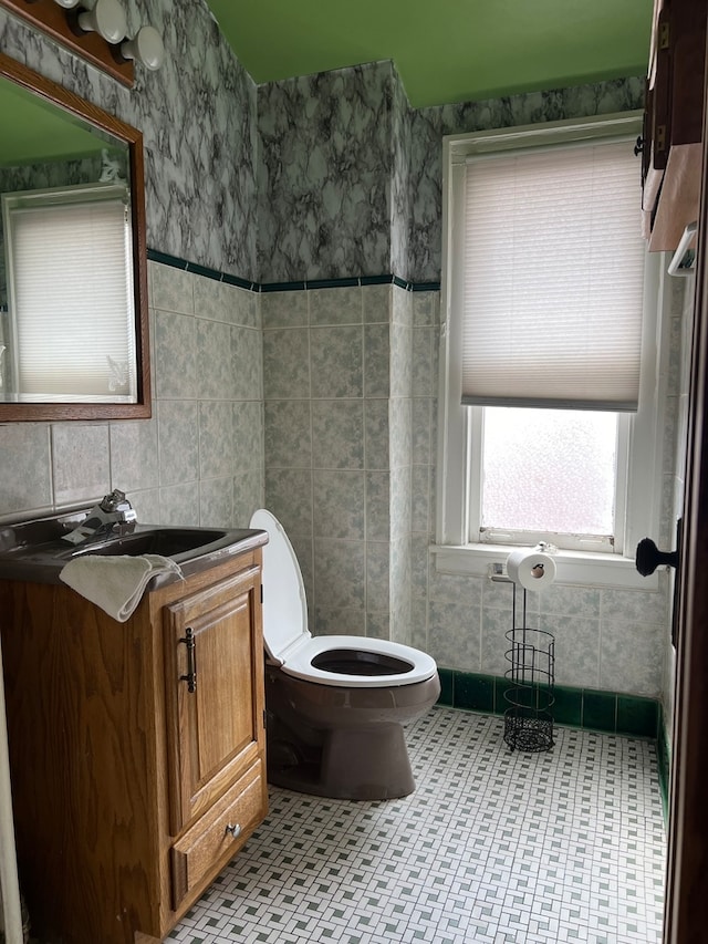 bathroom with tile patterned floors, vanity, tile walls, and toilet