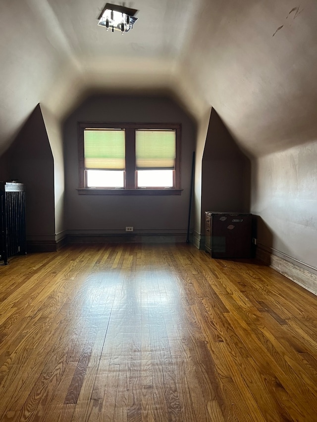 bonus room featuring radiator heating unit, hardwood / wood-style flooring, and vaulted ceiling