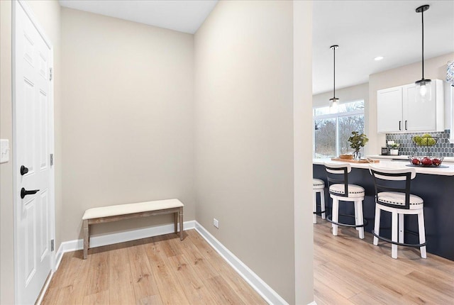 hallway with light wood-style flooring and baseboards