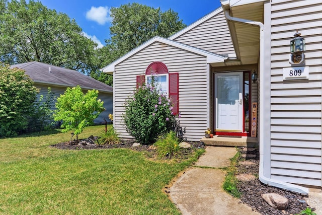 doorway to property featuring a lawn