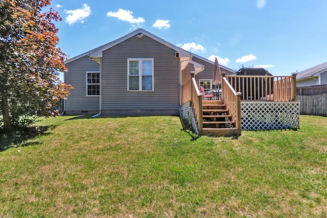 rear view of house featuring a deck and a lawn