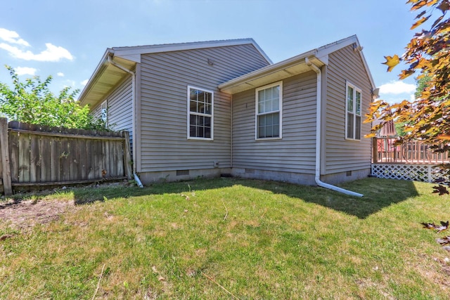 rear view of house with a yard and a wooden deck