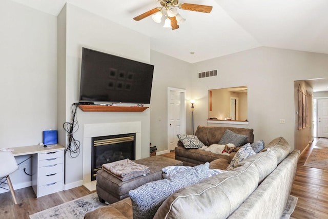 living room with ceiling fan, light hardwood / wood-style floors, and lofted ceiling