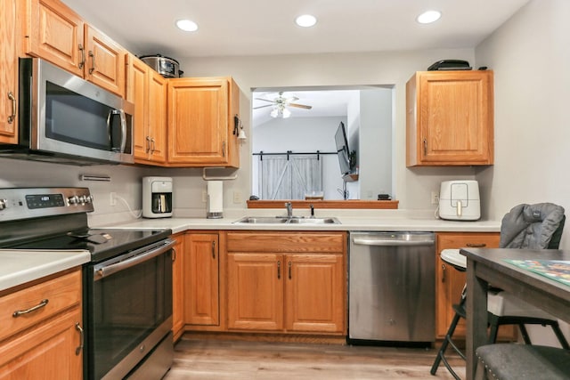 kitchen featuring ceiling fan, light wood-type flooring, sink, and appliances with stainless steel finishes