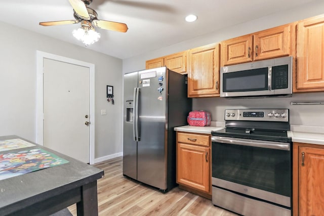 kitchen with ceiling fan, appliances with stainless steel finishes, and light hardwood / wood-style flooring