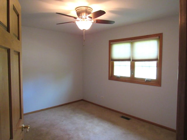 spare room with ceiling fan and light colored carpet