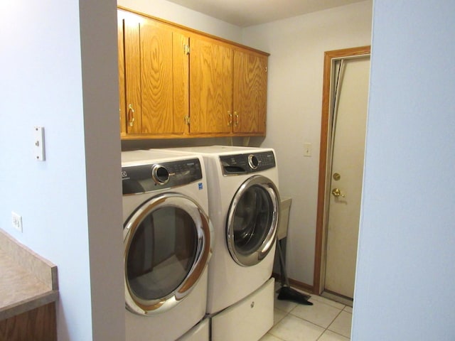 laundry room featuring cabinets, washer and dryer, and light tile patterned floors