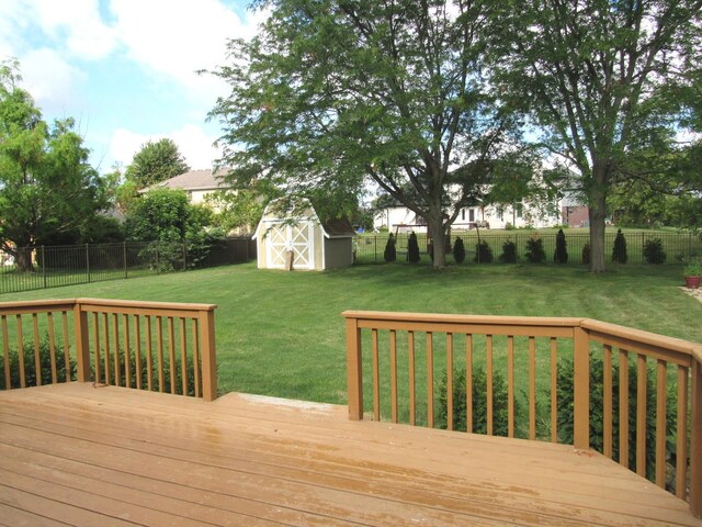 wooden terrace featuring a storage unit and a yard