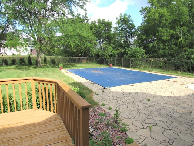 view of pool featuring a patio, a deck, and a lawn