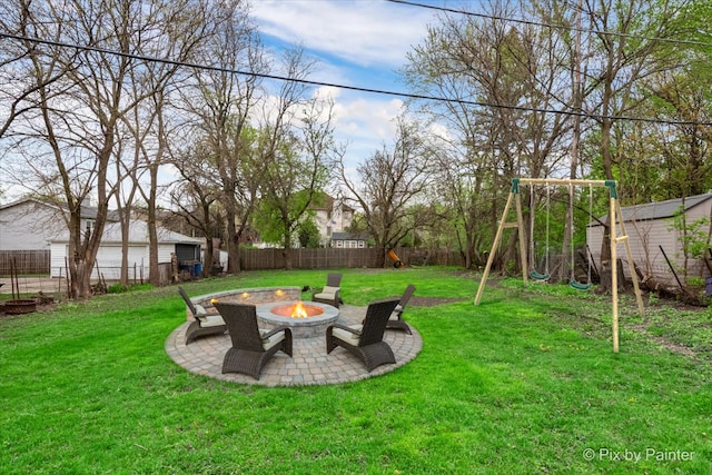 view of yard featuring a playground, a patio, and an outdoor fire pit