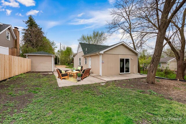 rear view of property with a patio area, an outdoor structure, and a yard