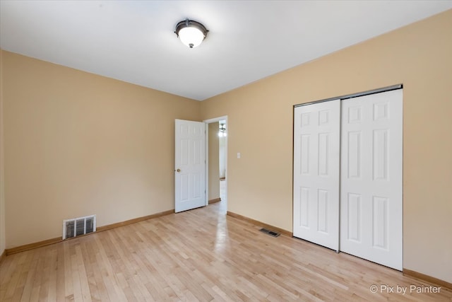 unfurnished bedroom featuring light hardwood / wood-style flooring and a closet