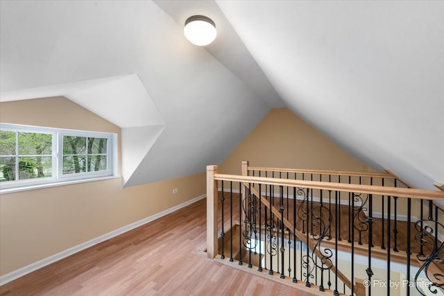 interior space featuring light wood-type flooring and vaulted ceiling