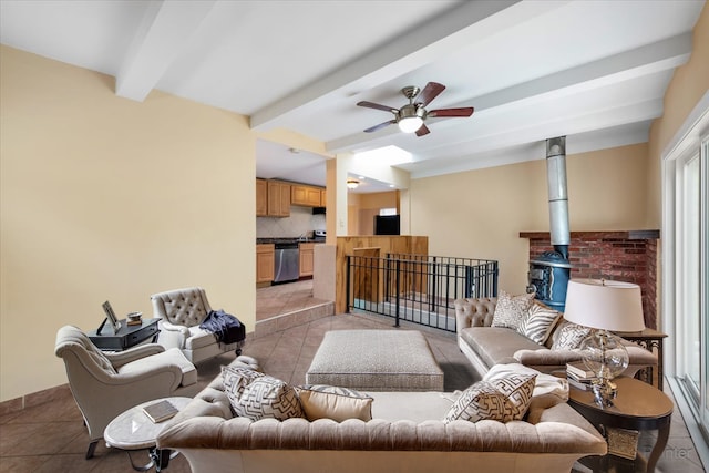 living room with beam ceiling, a wood stove, light tile patterned floors, and ceiling fan