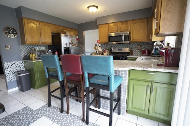 kitchen with decorative backsplash, light tile patterned flooring, sink, and appliances with stainless steel finishes