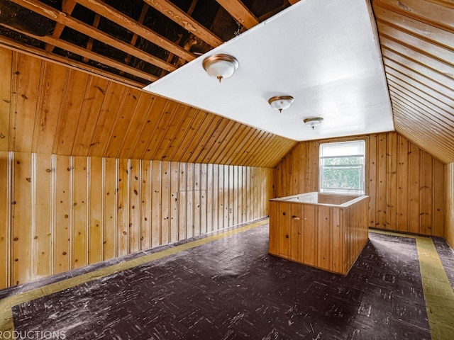 additional living space with lofted ceiling and wooden walls