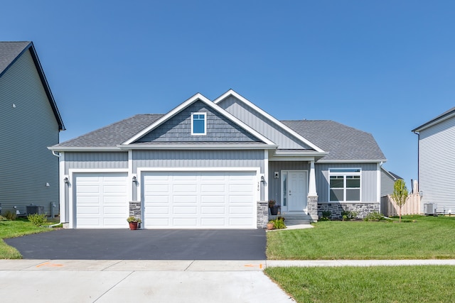 craftsman-style home featuring cooling unit, a garage, and a front yard