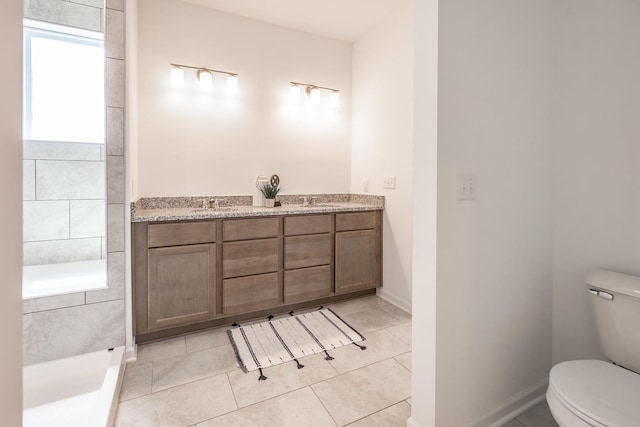 full bathroom featuring double vanity, tile patterned flooring, toilet, and a sink