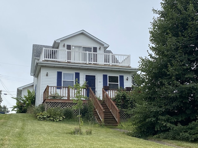 view of front of property featuring a front yard and a balcony