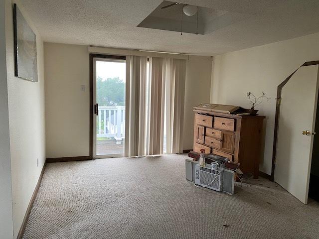 interior space featuring a textured ceiling, light colored carpet, and ceiling fan