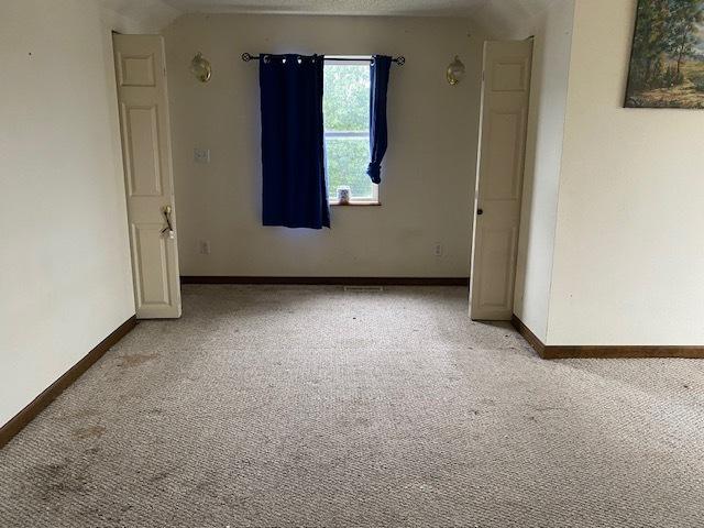 carpeted empty room featuring a textured ceiling