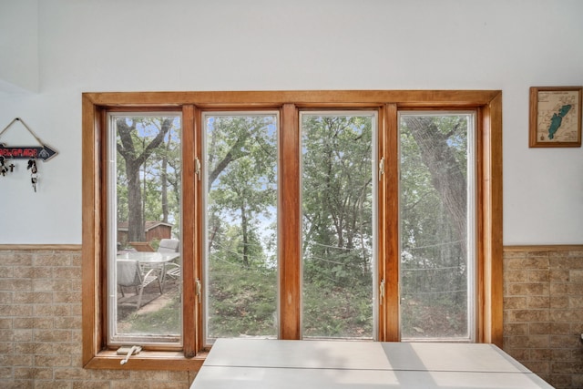 doorway featuring a wainscoted wall and a wealth of natural light