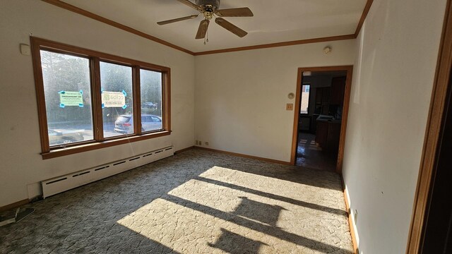 carpeted spare room with a wealth of natural light, baseboards, crown molding, and baseboard heating