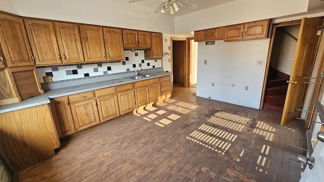 kitchen featuring tasteful backsplash, ceiling fan, brown cabinets, wood finished floors, and a sink