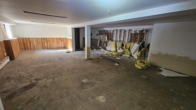 interior space with wainscoting and wooden walls