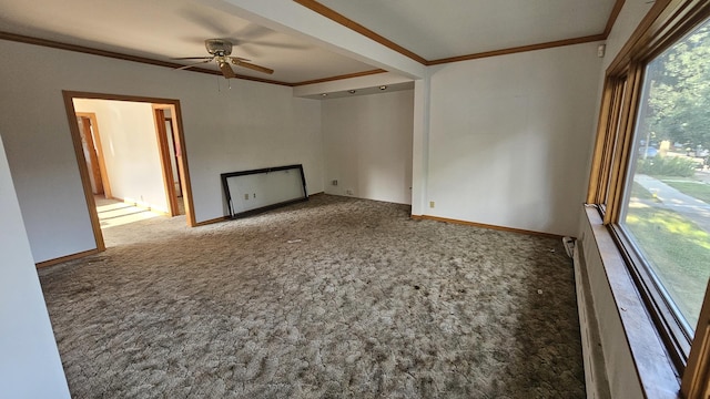 empty room with carpet floors, ornamental molding, baseboards, and a ceiling fan