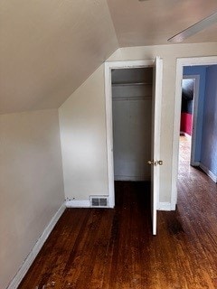 additional living space with hardwood / wood-style floors and lofted ceiling