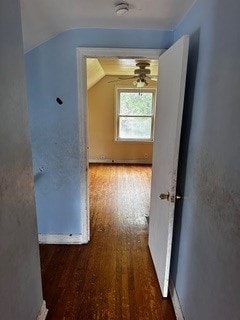 hallway with vaulted ceiling and hardwood / wood-style flooring