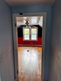 additional living space featuring ceiling fan, vaulted ceiling, and wood-type flooring